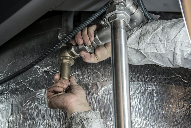 Pro from local Houston commercial plumbing company fixing plumbing